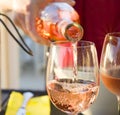 The waiter pours the pink french wine into the glass Sparks