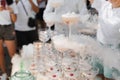 The waiter pours sparkling wine into crystal glasses with dry ice and white smoke close up. Champagne pouring in wine Royalty Free Stock Photo