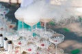 The waiter pours sparkling wine into crystal glasses with dry ice and white smoke close up. Champagne pouring in wine Royalty Free Stock Photo