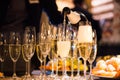 Waiter pours sparkling wine into the glasses