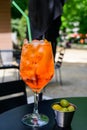 Waiter prepared the Aperol Sprits summer cocktail with Aperol, prosecco, ice cubes and orange in wine glass, ready to drink on Royalty Free Stock Photo