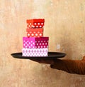 Waiter with presents on tray. Male hand holds boxes