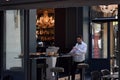 French waiter reads paper before morning rush