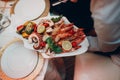 a waiter in a restaurant holds seafood dishes and serves a table catering Concept Healthy food octopus and crabs