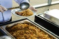 Waiter`s hands in sterile gloves with tongs and hot food Royalty Free Stock Photo