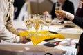 Waiter served champagne glasses on a tray in a fine dining restaurant and woman takes a glass. Royalty Free Stock Photo