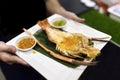 The waiter served a plate of grilled prawn on the banana leaf and Thai spicy sauce.