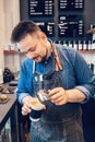 Waiter server pouring hot milk drink in coffee paper cup. Small business and person at work concept