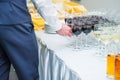 The waiter is servering catering buffet table with alcoholic and non-alcoholic drinks on the business event in the hall. Service a Royalty Free Stock Photo