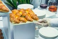 The waiter is servering catering buffet table with food and snacks for guests of the event. Dining Food Celebration Party Concept. Royalty Free Stock Photo