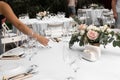 The waiter serves banquet table. Wedding table setting decorated with flowers and brass candlesticks with candles Royalty Free Stock Photo