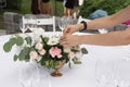 The waiter serves banquet table. Wedding table setting decorated with flowers and brass candlesticks with candles Royalty Free Stock Photo