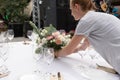 The waiter serves banquet table. Wedding table setting decorated with flowers and brass candlesticks with candles Royalty Free Stock Photo