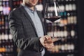 Waiter serves glass of red wine in restaurant, dark background Royalty Free Stock Photo