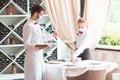 The waiter serves a table in a cafe in a protective mask Royalty Free Stock Photo