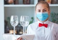 The waiter serves a table in a cafe in a protective mask Royalty Free Stock Photo