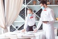 The waiter serves a table in a cafe in a protective mask Royalty Free Stock Photo