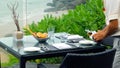 Waiter serves a table at a sea view restaurant Royalty Free Stock Photo