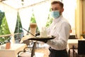 Waiter serving beverages in restaurant. Catering during coronavirus quarantine