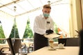 Waiter serving beverages in restaurant. Catering during coronavirus quarantine