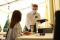 Waiter serving beverages to customer in restaurant. Catering during coronavirus quarantine