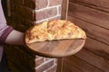 Waiter serving and carrying plate with a tasty big closed italian Calzone pizza. Ham, tomato and cheese. Italian cuisine Royalty Free Stock Photo