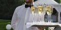 Waiter serving champagne on a tray Royalty Free Stock Photo