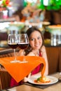 Waiter serving Chinese woman red wine