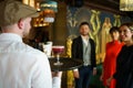 Waiter serving a cocktail for elegant guests in a nice bar