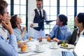 Waiter serving coffee to business people Royalty Free Stock Photo
