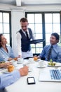 Waiter serving coffee to business people Royalty Free Stock Photo