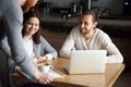 Waiter serving coffee to happy millennial couple in cafe Royalty Free Stock Photo