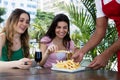 Waiter serving french fries to guests