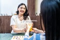 Waiter serving glass of fresh juice to customer who was a asian woman on counter Royalty Free Stock Photo