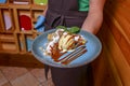 Waiter serving ice cream dessert in restaurant or diner. Eating out concept. Apple pie with ice cream and caramel sauce