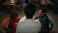 Waiter serving multiethnic couple in cafe bar. Romantic partners ordering dinner Royalty Free Stock Photo