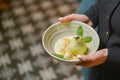 Waiter serving sweet unique dessert. White chocolate pear served in a bowl in restaurant.