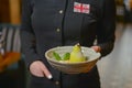 Waiter serving sweet unique dessert. White chocolate pear served in a bowl in restaurant.