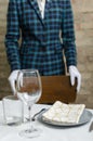 Waiter wearing classic jacket and waiting for guest.Closeup of empty glasses,plate on the restaurant table Royalty Free Stock Photo