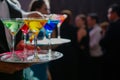 waiter serving tray of colorful martinis to guests at an upscale event Royalty Free Stock Photo