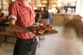 Waiter serving up a board of freshly baked nachos Royalty Free Stock Photo