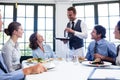 Waiter serving water to business people Royalty Free Stock Photo