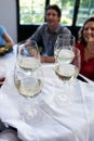 Waiter serving wine to friends in restaurant