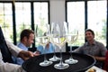 Waiter serving wine to friends in restaurant