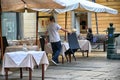 Waiter setting up restaurant terrace tables