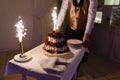 Waiter in the shape of the restaurant pulls out a beautiful wedding yogurt cake with the inscription love and burning fires with s Royalty Free Stock Photo