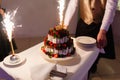 Waiter in the shape of the restaurant pulls out a beautiful wedding yogurt cake with the inscription love and burning fires with s Royalty Free Stock Photo