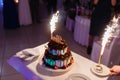 Waiter in the shape of the restaurant pulls out a beautiful wedding yogurt cake with the inscription love and burning fires with s Royalty Free Stock Photo