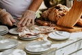 Waiter slicing and serving on separate plates roasted pork leg