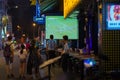 Waiter in T-shirt of Argentina blue-white design with writing `Champion` watches TV screen with football broadcast at Champion Bar